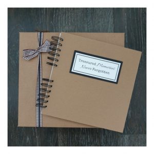 kraft brown scrapbook and gift box with a label that reads Treasured memories never forgotten
