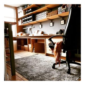 craft room with organised shelves, rug and computer chair